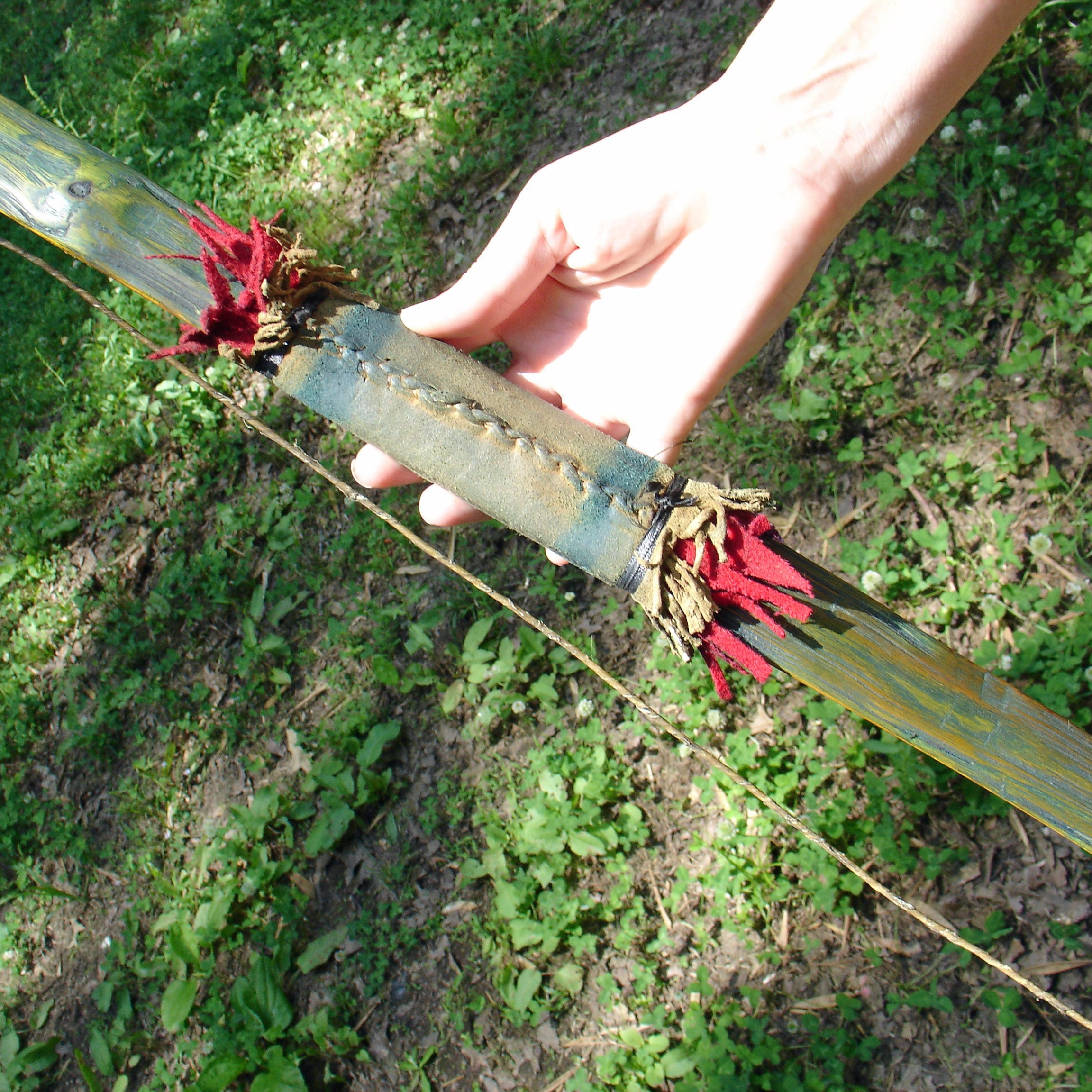 Comanche style Bow stitched leather handle detail with red trade cloth fringe
