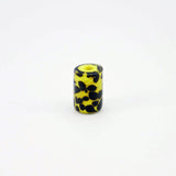 Yellow glass bead with black tadpole-like dots standing on end