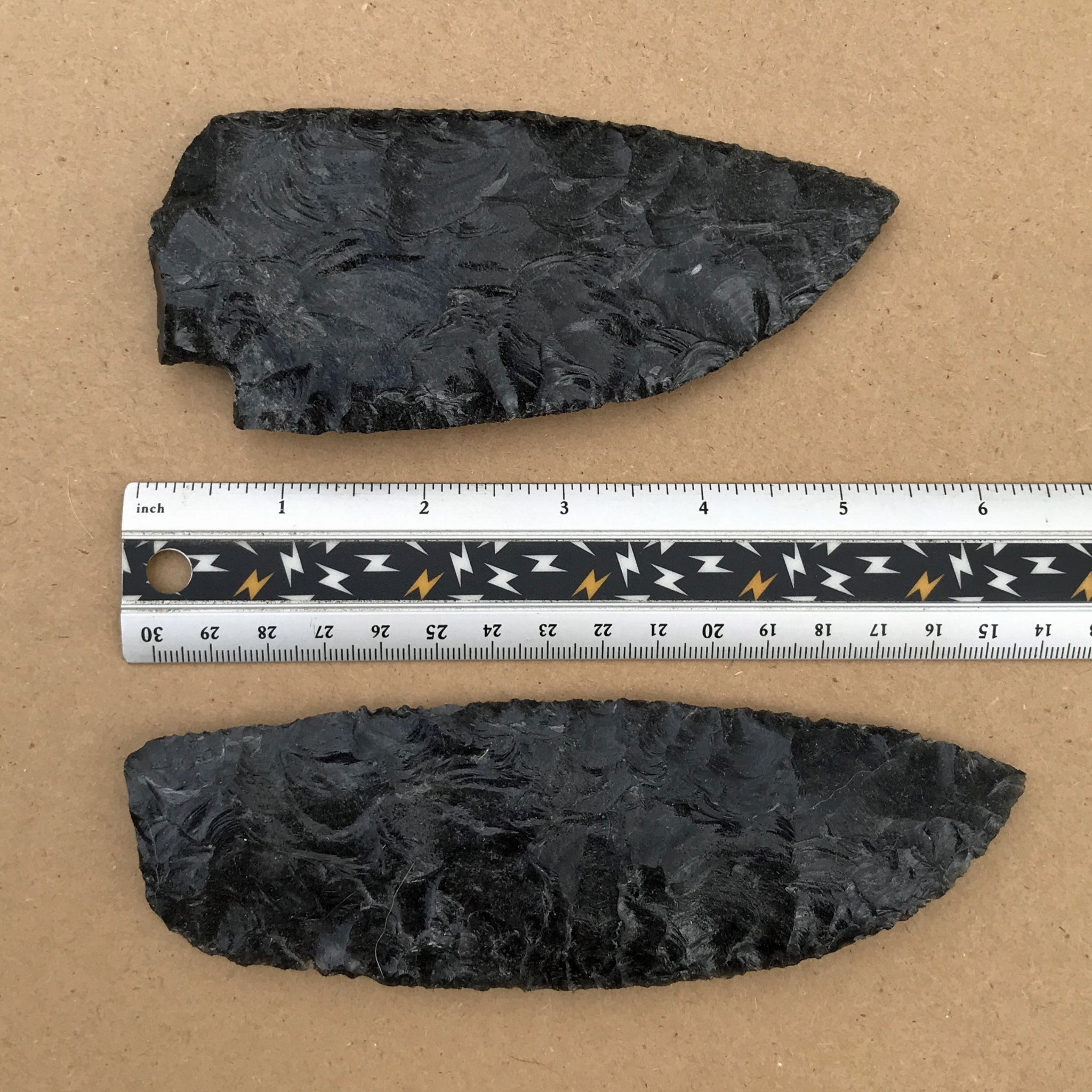 2 black sheen obsidian blades with ruler for scale