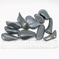 Assorted tumbled dacite palm stones with ruler