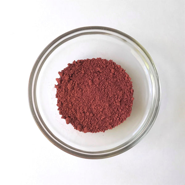 bowl of dull red ochre powdered pigment