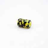 Black tadpole dots on yellow core glass cylinder bead