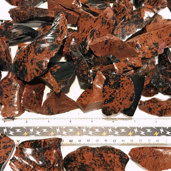 Group of mahogany obsidian rough tumbling material with ruler