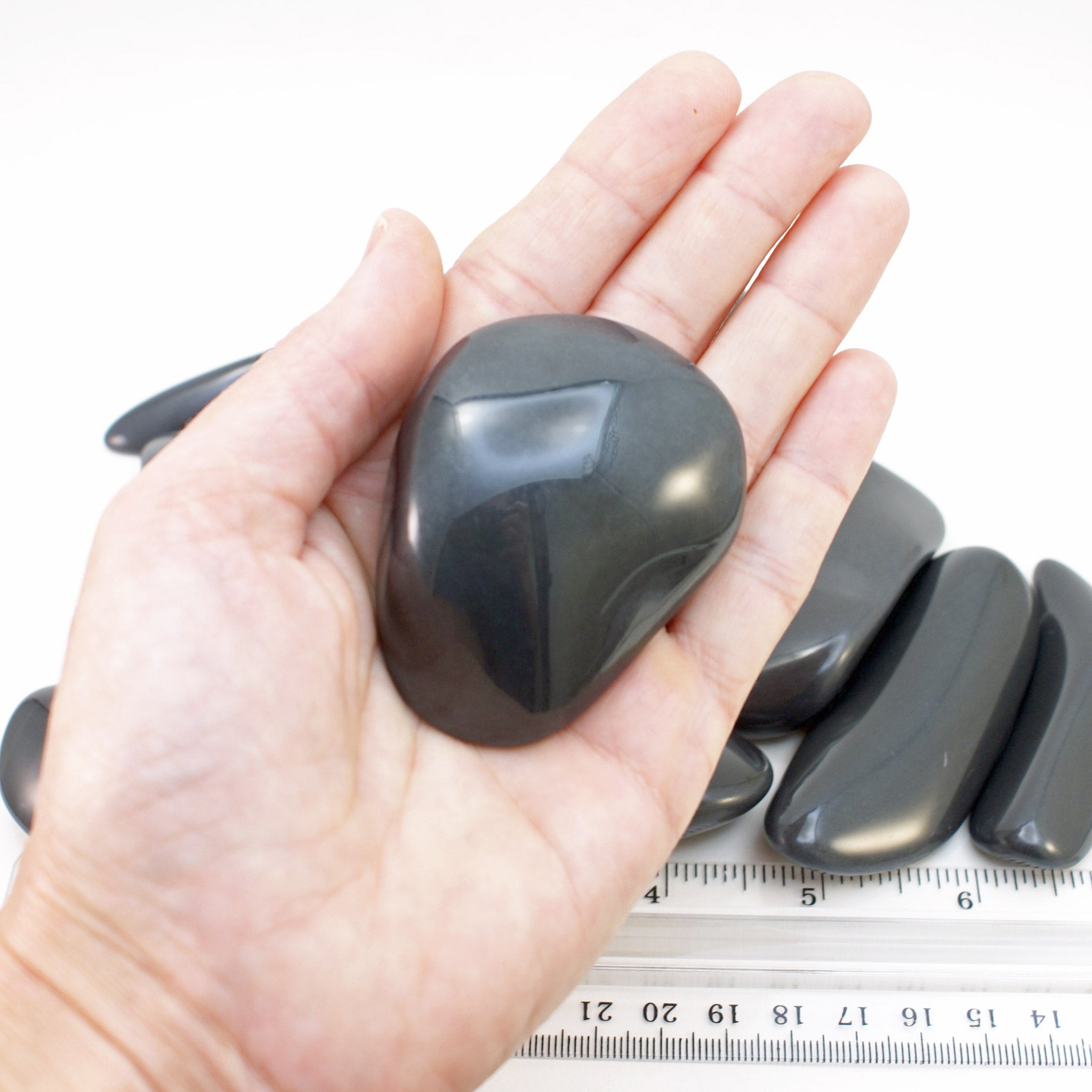 Extra-large polished dacite palm stone in hand